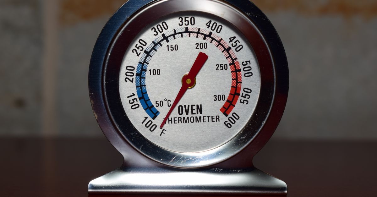 Close-up of a metallic oven thermometer showing temperature in Celsius and Fahrenheit.
